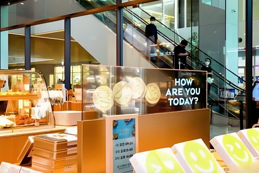 Transparent OLED display showcasing products in a retail window, blending digital content and physical items seamlessly.